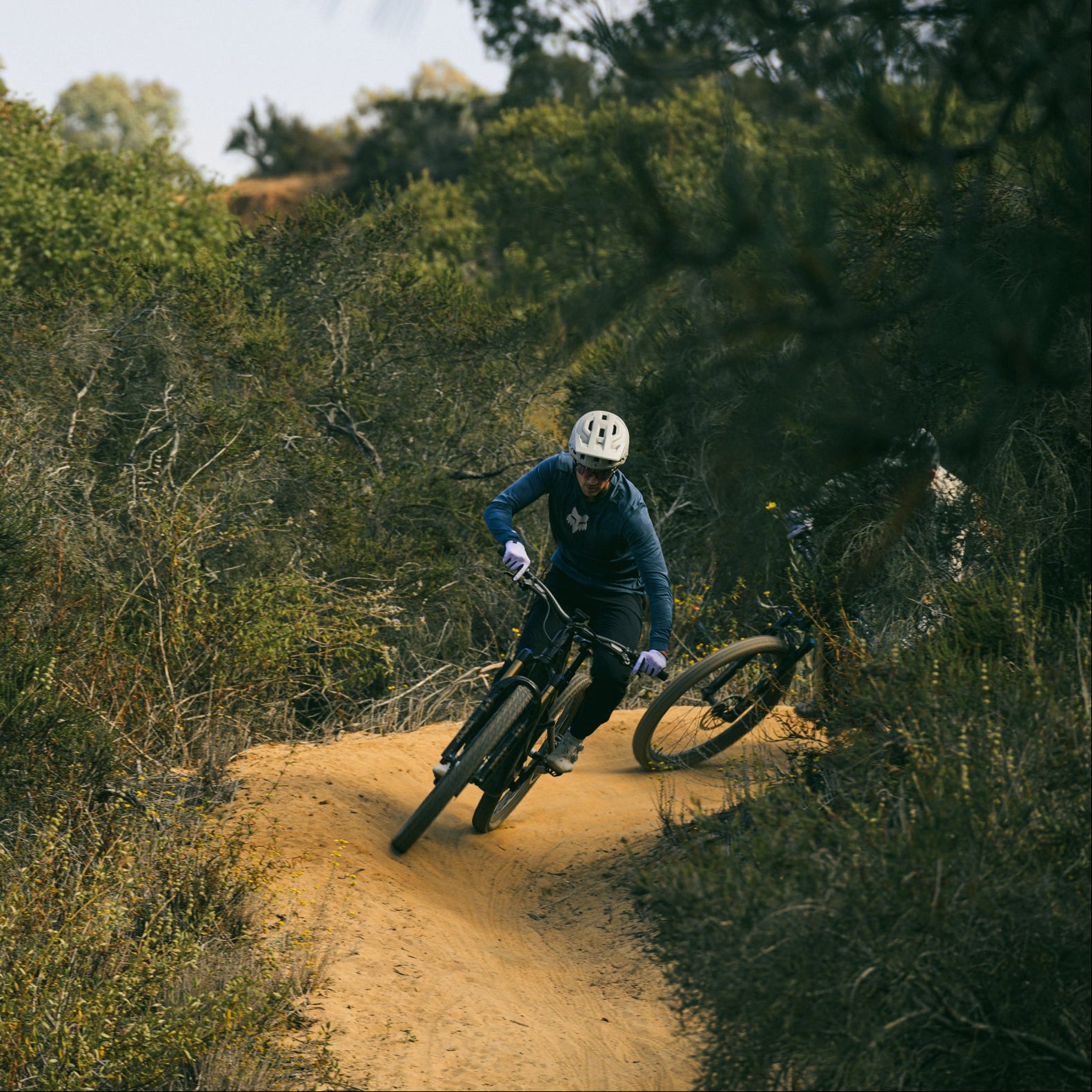 Person riding a new levo R on a dirt trail surrounded by trees 
