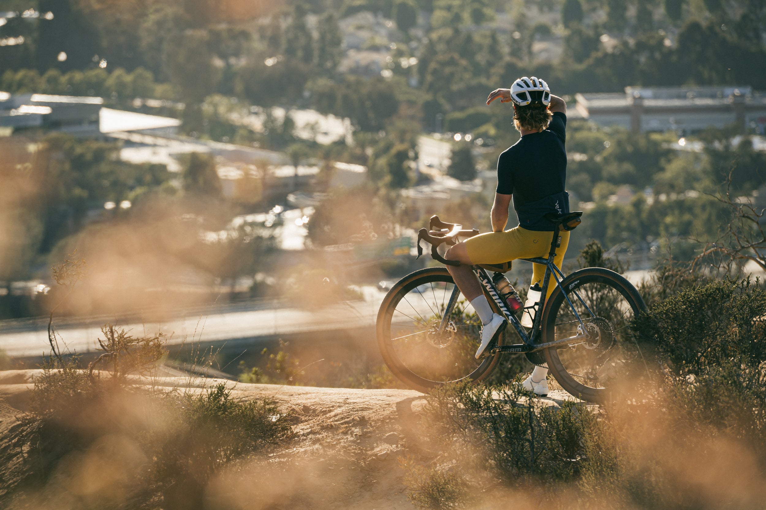Person with a bicycle overlooking a scenic landscape gravel cycling in San Diego.